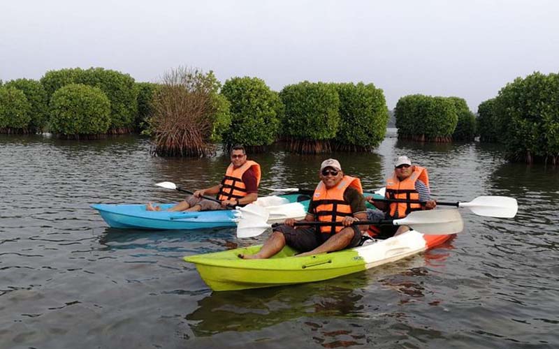 Tourists enjoying kayaking in Kannur backwaters near Parassinikadavu Temple – guided activity by Kannur Houseboat